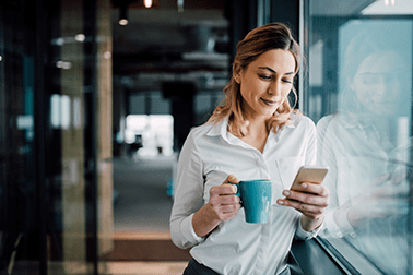 Woman-looking-at-her-phone-with-a-coffee-in-her-hand-378